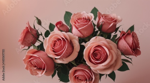 Bouquet of pink roses in vase on pink background.