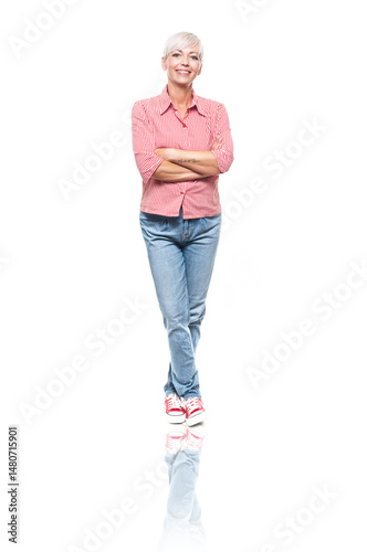 Full length portrait of positive adult woman with crossed arms, isolated on white background. Cheerful middle aged woman standing and looking to camera.