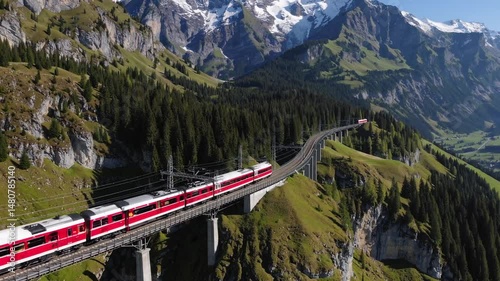 Alpine railway in Switzerland, red Swiss train moving in the Alps mountain range