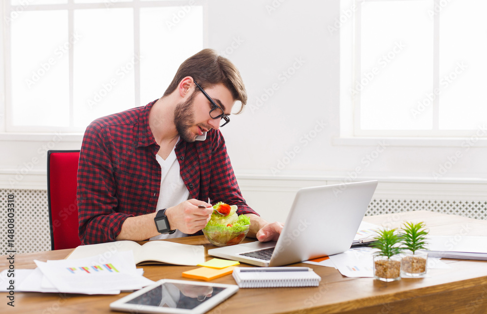 Busy at work. Man has business lunch in office, talking on mobile and reading papers. Overworking concept. Busy at work. Man has business lunch in office, talking on mobile and reading papers. Overworking concept.