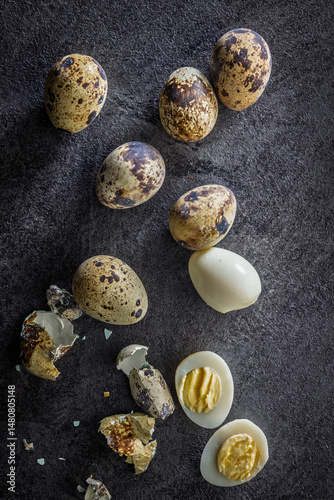 Boiled quail eggs on black table. Top view.