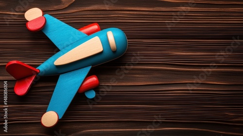 A colorful wooden toy airplane resting on a wooden surface