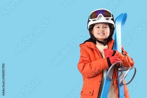 Little Asian girl with skis...