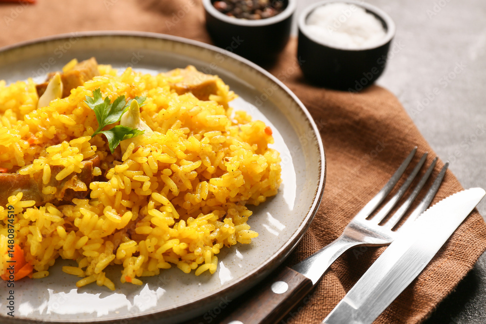 Plate with tasty pilaf and bowl of salt on black background, closeup Plate with tasty pilaf and bowl of salt on black background, closeup