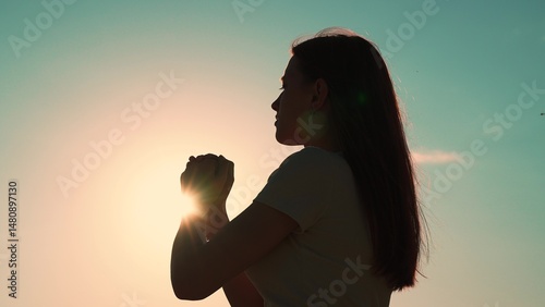 Canvas Print Young woman praying at sunset, Silhouette