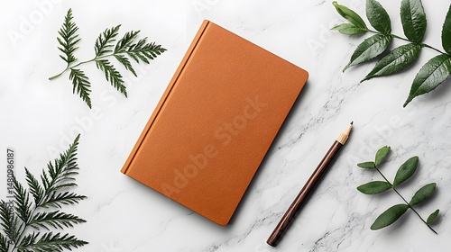Brown Hardcover Book Mockup with Green Leaves and Pencil on White Marble