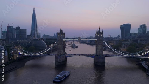 A breathtaking aerial perspective of the iconic Tower Bridge illuminated at twilight, perfectly highlighting the striking and beautiful London skyline that stretches along the River Thames