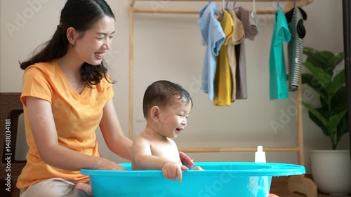 Mom and little child with taking a shower and dressing at home in the morning