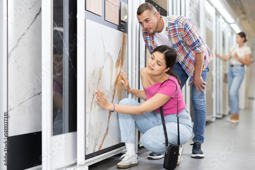 Young married couple chooses floor tiles for their home together