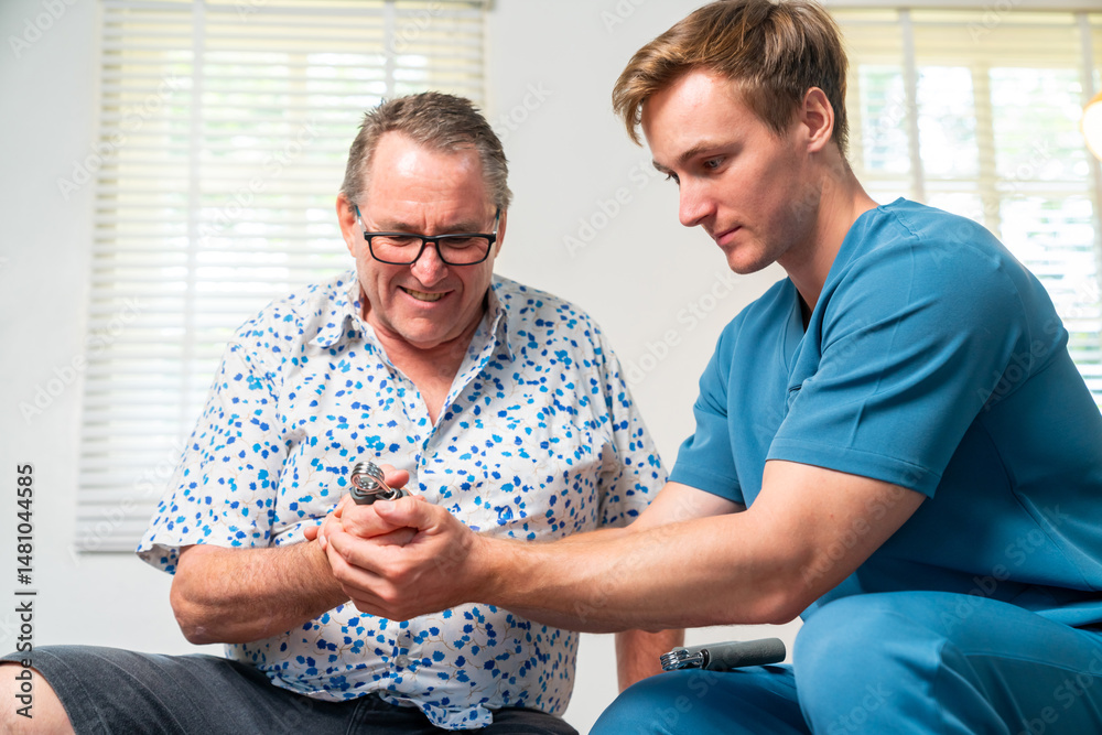 Obraz premium Physical therapist doctor teach senior man patient finger wrist and hand muscle exercise with sport equipment at Physiotherapy clinic. Medical healthcare and physical rehabilitation in elderly people.