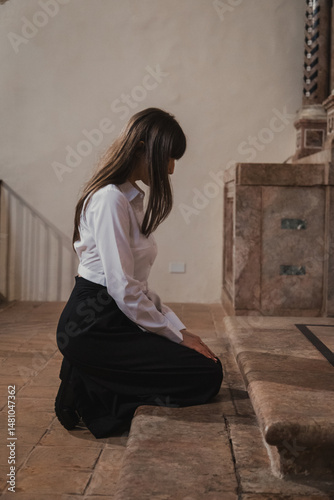 Woman Looking Up In The Church While Praying On Her Knees 