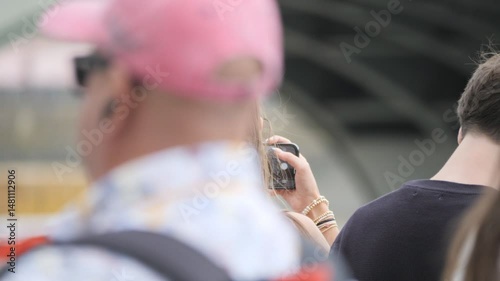 London, England, UK - August 10, 2024: A tourist woman on the London riverside taking pictures.