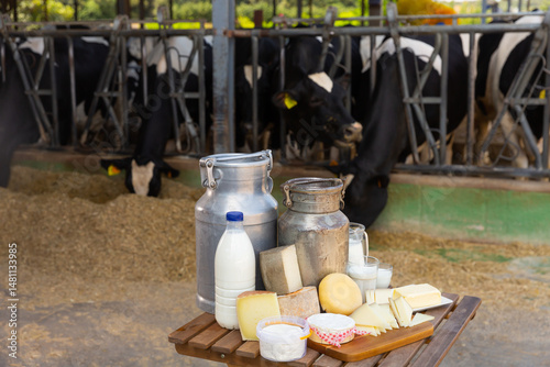 Obraz na płótnie Image of fresh dairy products on the table on the farm against the background of cows w salonie