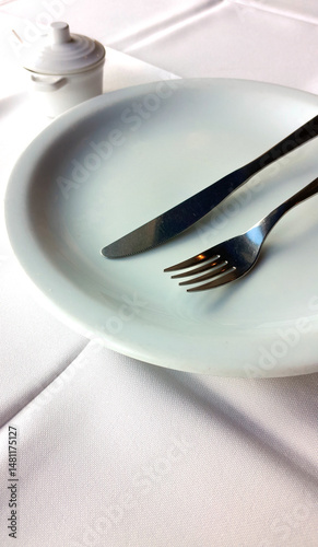 Prato branco de porcelana vazio com talheres em cima