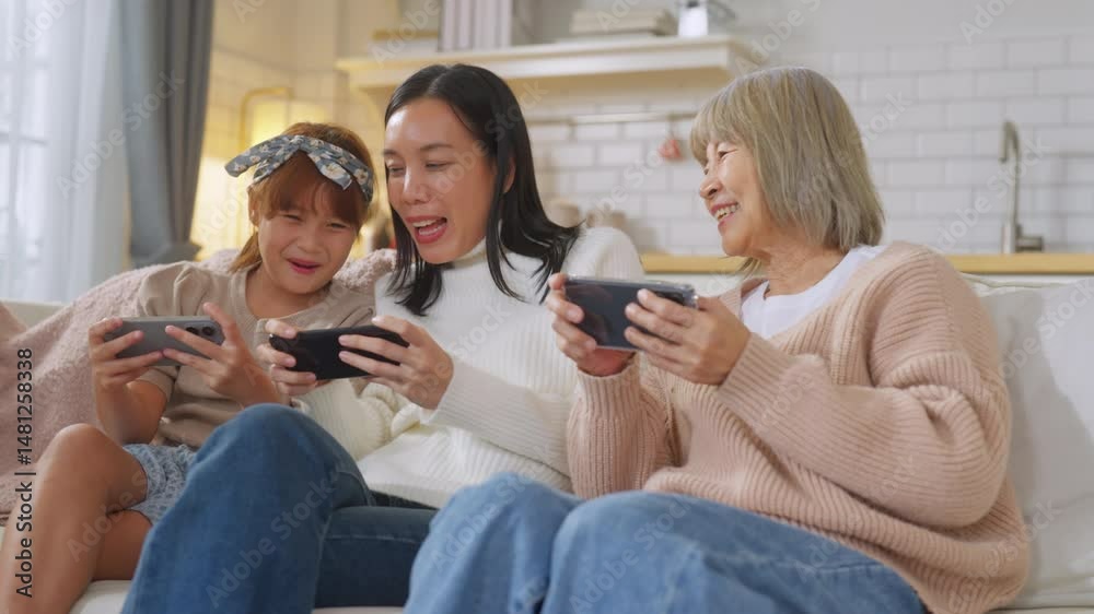 Asian family with smartphone game online technology Grandmother learning new technologies with granddaughters using smartphones at home Laughing intergenerational family spending leisure time Asian family with smartphone game online technology Grandmother learning new technologies with granddaughters using smartphones at home Laughing intergenerational family spending leisure time