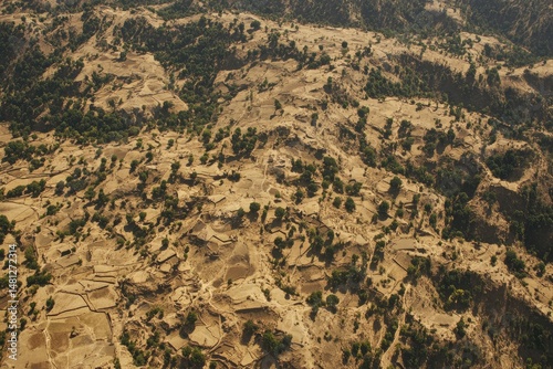 High-altitude view of arid hillsides and agricultural terraces.