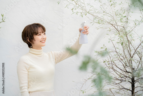 植物に水を吹き付ける女性