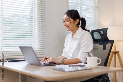 Business Asian woman using calculator and laptop for doing math finance on an office desk, tax, report, accounting, statistics, and analytical research concept
