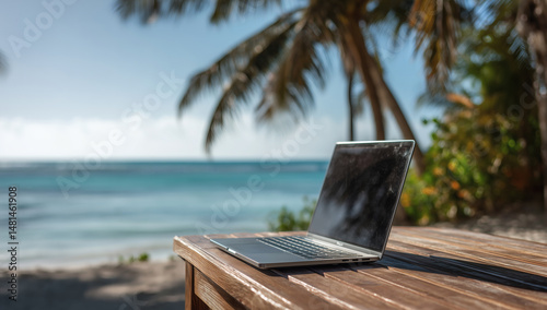 Fototapeta Naklejka Na Ścianę i Meble -  Laptop on wooden table at tropical beach
