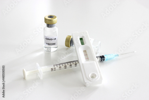 Vial of Covid-19 vaccine, 1 ml plastic syringe with needle and Positive test result of Covid-19 antigen test kit isolated on the white background