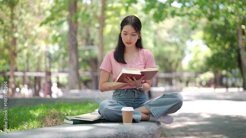Tranquility in the Park: A young woman finds solace and escape in the pages of a captivating book, surrounded by the lush greenery of a peaceful park.