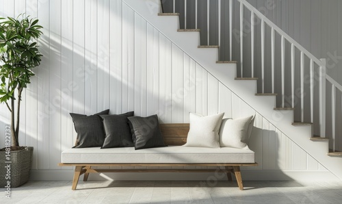 Obraz na płótnie Wooden bench with black and white pillows sits beneath a white staircase in a minimalist room. w salonie