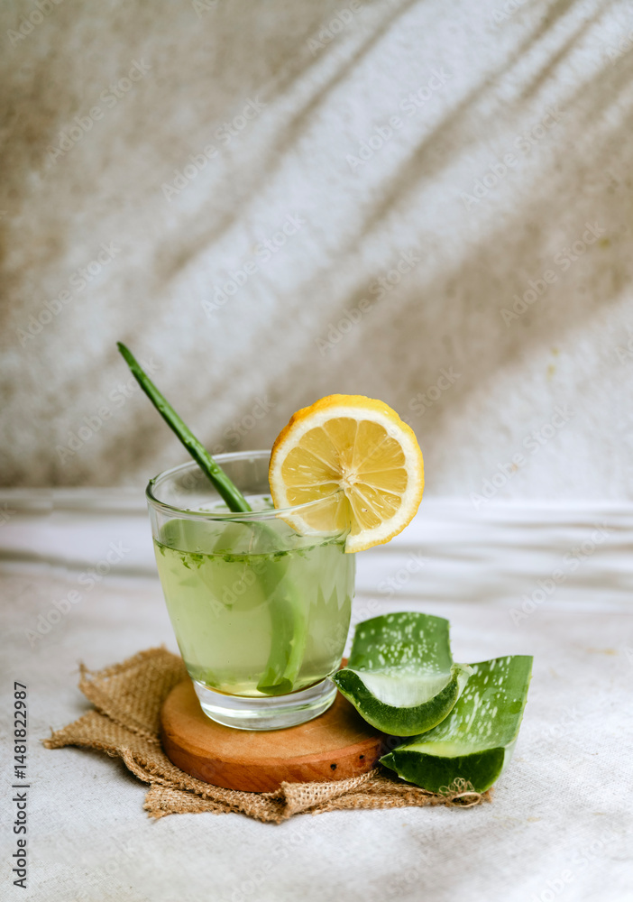 Fototapeta premium Fresh aloe vera drink in glass cup with aloe slices 