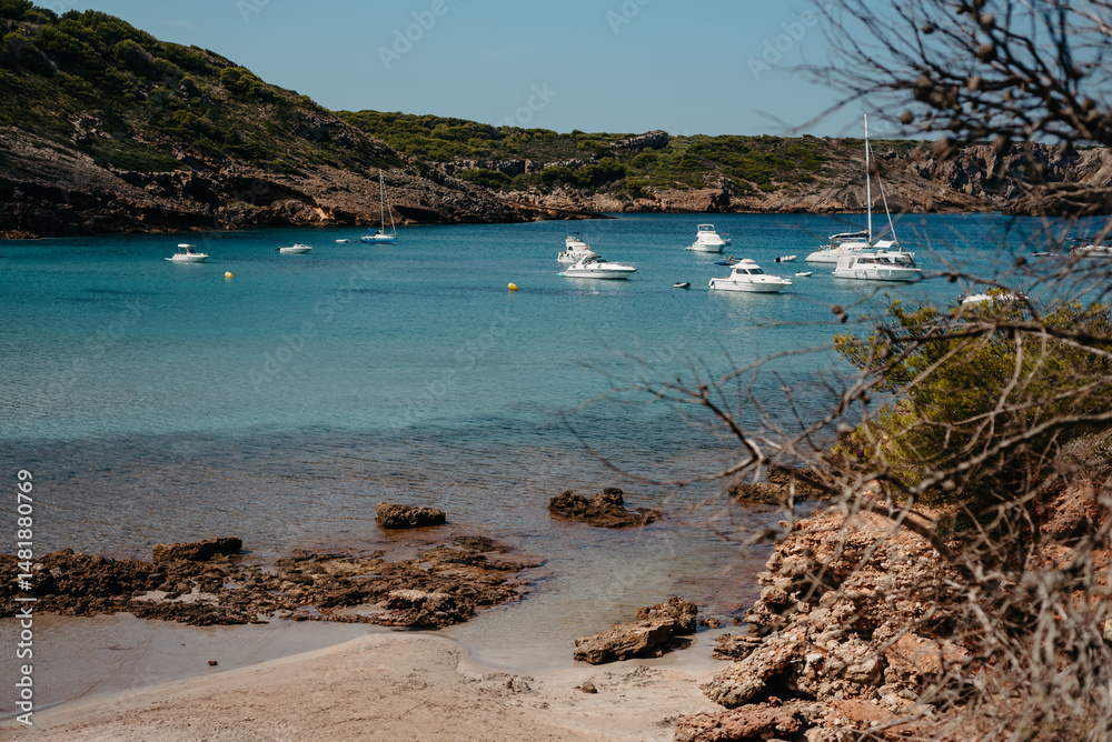 Obraz premium Anchored boats in turquoise waters at Cala Algaiarens, Menorca