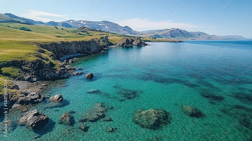 Fototapeta premium Turquoise coastal scenery with rocky shores and distant mountains