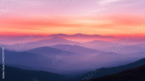 Pink and orange sunset casts a serene glow over foggy mountains, creating a breathtaking view that evokes tranquility and wonder