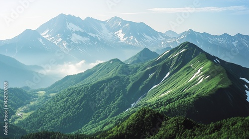 Verdant Mountain Range: Layers of Green Peaks with Distant Snow-Capped Summits