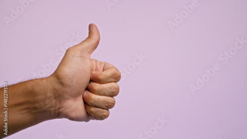 Man's hand giving a thumbs up against a pastel purple background highlighting positivity and approval