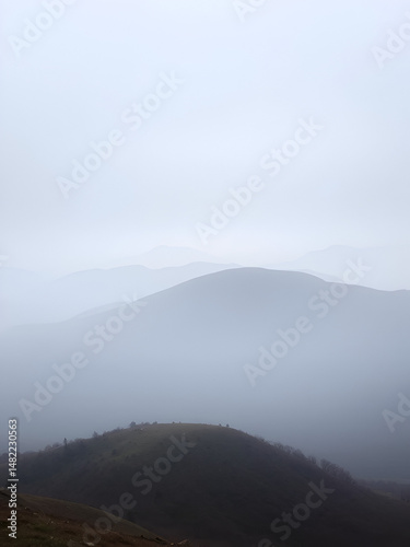 Fading Landscape: Hills recede into the mist, leaving behind a sense of quiet isolation.