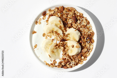 Natural Greek Yogurt with Homemade Granola with Walnuts, Sunflower Seeds, Raisins, Almonds, and Banana Slices on Top. Breakfast Food.