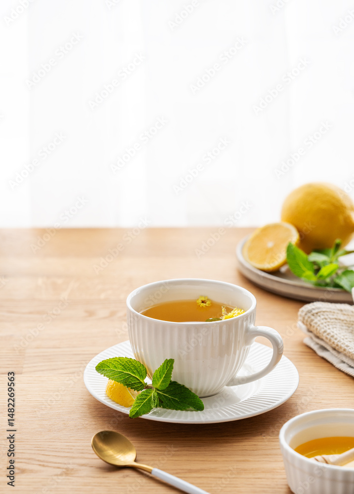 Cup of herbal tea with lemon, honey and mint on wooden tabletop Cup of herbal tea with lemon, honey and mint on wooden tabletop