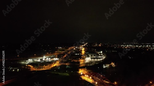 Wallpaper Mural A drone flies above Youngstown, Ohio at night, capturing glowing streetlights along a major road that cuts through the city under a dark sky. Torontodigital.ca