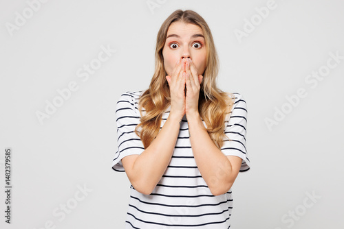 Young happy shocked surprised Caucasian woman she wearing striped t-shirt casual clothes cover mouth with hand look camera isolated on plain solid white background studio portrait. Lifestyle concept.