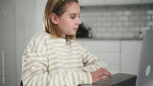Cute Little Girl Doing Homework And Browsing The Internet On Laptop For Assistance