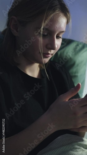 Happy Cute Little Girl Plays A Game On Smartphone In Bed Before Sleep, Vertical Video