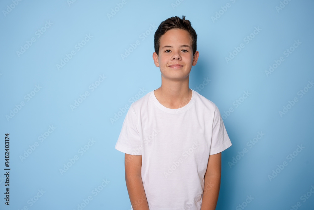 Obraz premium Child boy wearing white t-shirt standing isolated over light blue background.