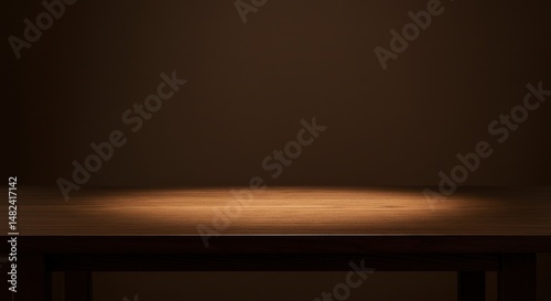 Empty wooden table illuminated by soft light against a dark background