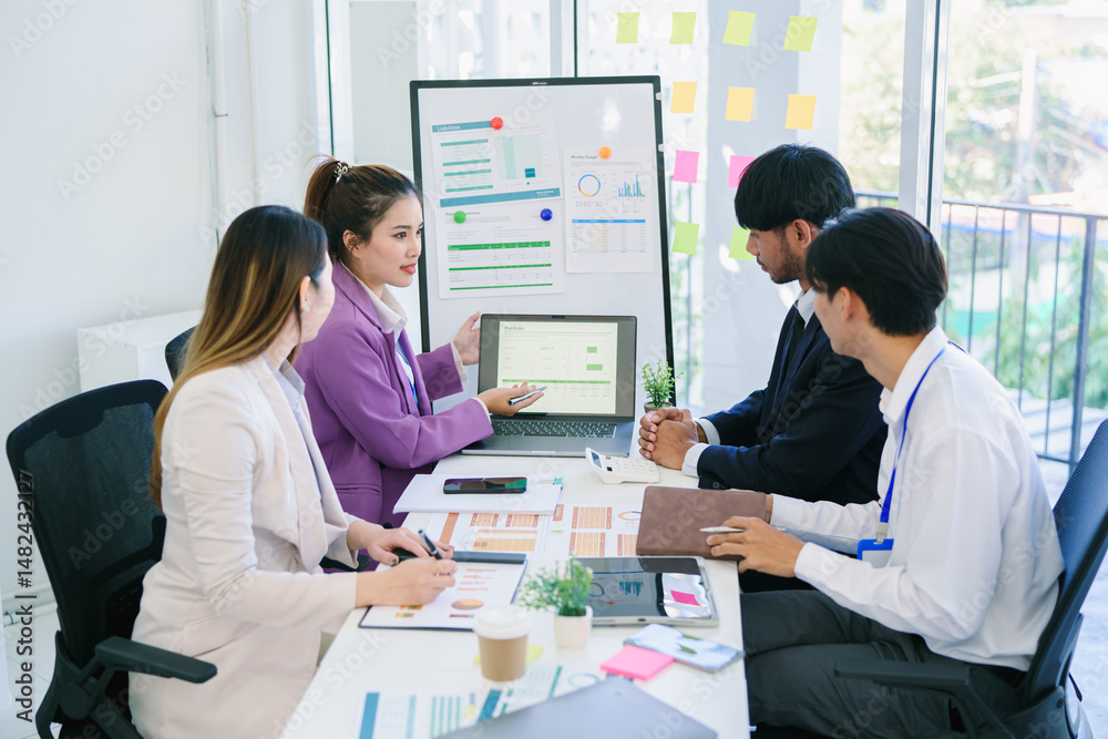 Fototapeta premium Business team woman and man asian group meeting sitting on desk looking talk think creative idea computer on table ready happy working new project job online product sale marketing in office company.