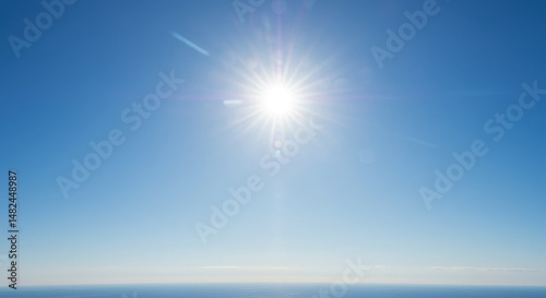 Bright sun shining over a clear blue sky above a tranquil ocean horizon