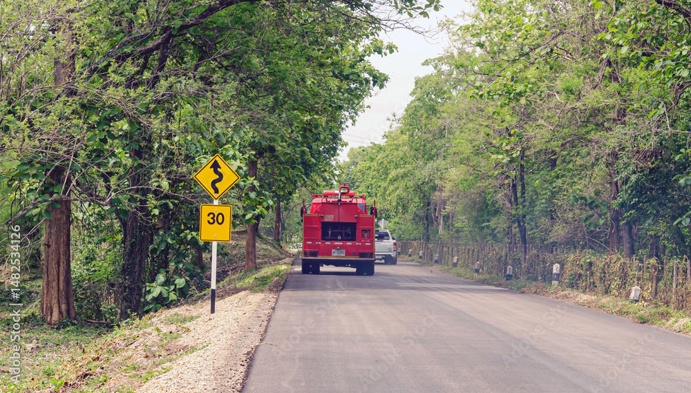 Obraz premium Traffic signs indicate winding roads and limit speeds on rural roads.