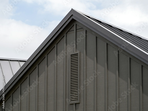 Modern gable roof with vertical cladding and ventilation grille - architectural detail