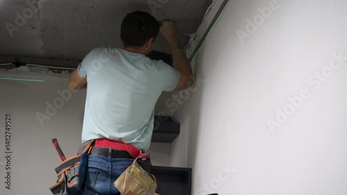 The worker adjusts a metal frame, ensuring every bolt is tighten