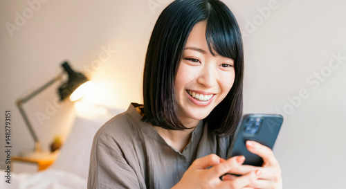 自宅でくつろぎながらスマホを見る女性