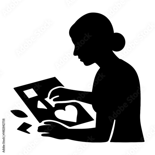 Silhouette of Person Crafting Cut-Out Shapes – Representation of DIY Creativity, Paper Art, and Hands-On Design