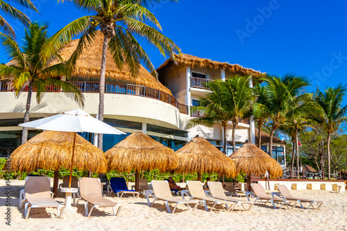 Palms parasols sun loungers beach resort Playa del Carmen Mexico.