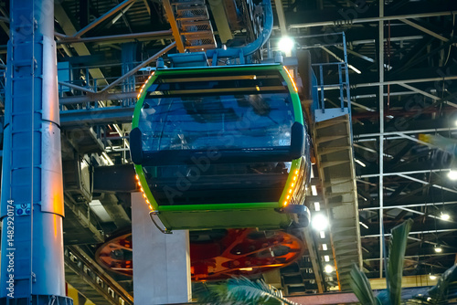 the cabin leaves the cable car parking lot, climbing up the cables. The technical elements are visible: supports, tensioned cables, lift mechanisms and electrical panels, as well as cable equipment